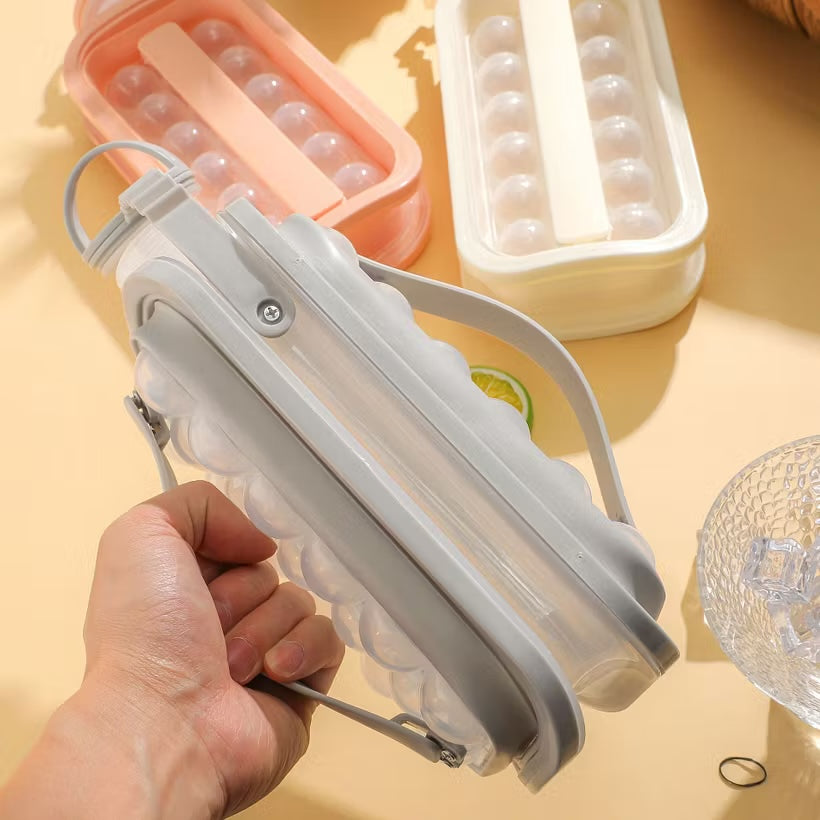 Hand holding the grey ice ball kettle to show its size and the flexible release panel